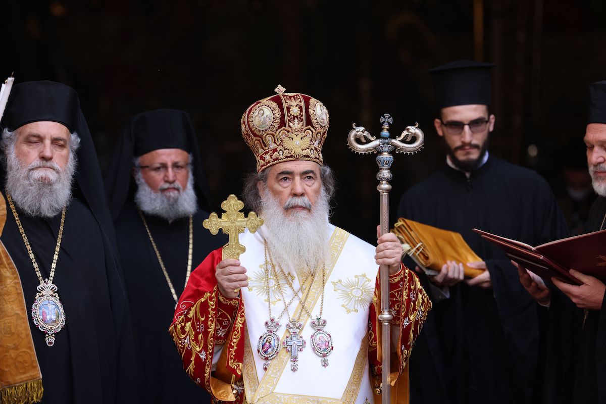 O Patriarca Ortodoxo Grego de Jerusalém Theophilos III (C) cercado por clérigos, chega para celebrar uma missa durante a Quinta-feira Santa no pátio da Igreja do Santo Sepulcro em Jerusalém, em 29 de abril de 2021 [Emmanuel Dunand/AFP via Getty Images]
