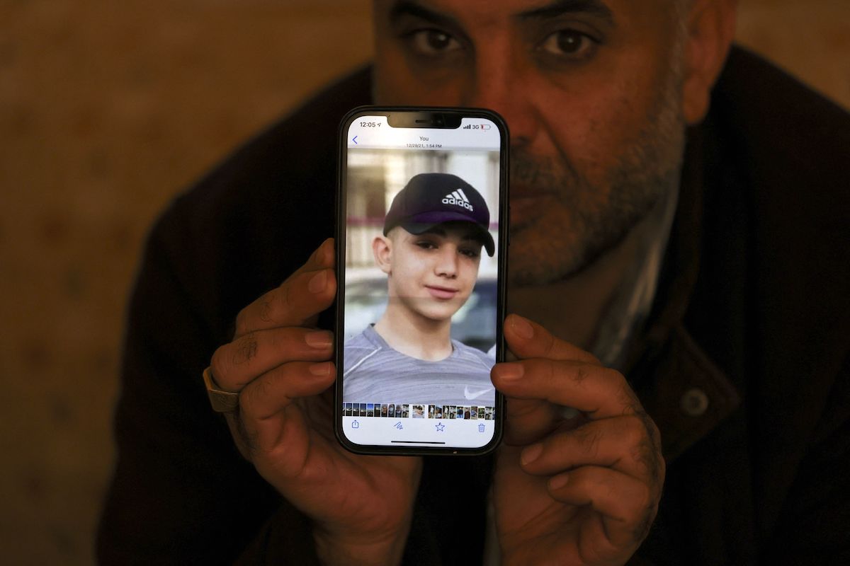 Moammar Nakhleh, pai do prisioneiro palestino Amal, de 17 anos, mostra uma fotografia do filho em seu celular, no campo de refugiados de Jalazum, perto de Ramallah, Cisjordânia ocupada, 8 de janeiro de 2022 [ABBAS MOMANI/AFP via Getty Images]
