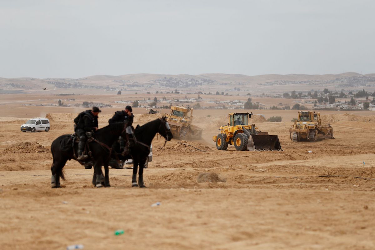 A polícia israelense monitora a situação enquanto os beduínos protestam na vila de Sawe al-Atrash, no sul de Israel, no deserto de Negev, contra um projeto de florestamento do Fundo Nacional Judaico, em 12 de janeiro de 2022 [Ahmad Gharabli/AFP via Getty Images]
