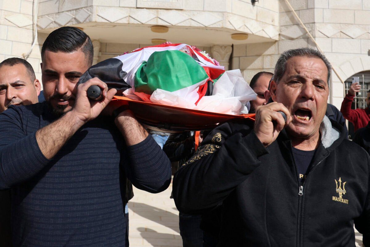 Parentes palestinos choram durante o funeral de Omar Abdalmajeed As'ad, 80, que foi encontrado morto após ser detido e algemado durante um ataque israelense, na aldeia de Jiljilya, na Cisjordânia ocupada por Israel, em 13 de janeiro de 2022 [Jaafar Ashtiyeh/AFP via Getty Images]
