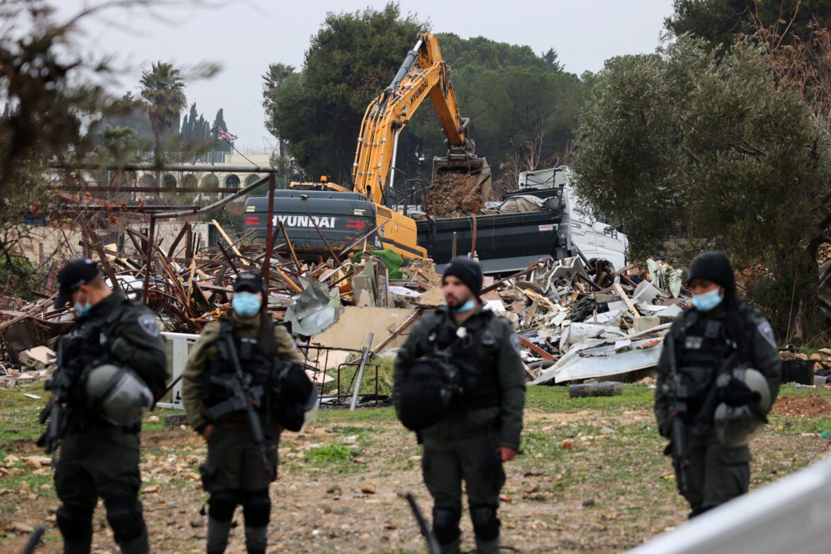 Forças israelenses montam guarda enquanto máquinas limpam as ruínas da casa da família palestina Salhiya, no bairro de Sheikh Jarrah, em 19 de janeiro de 2022 [Ahmad Gharabli/AFP via Getty Images]

