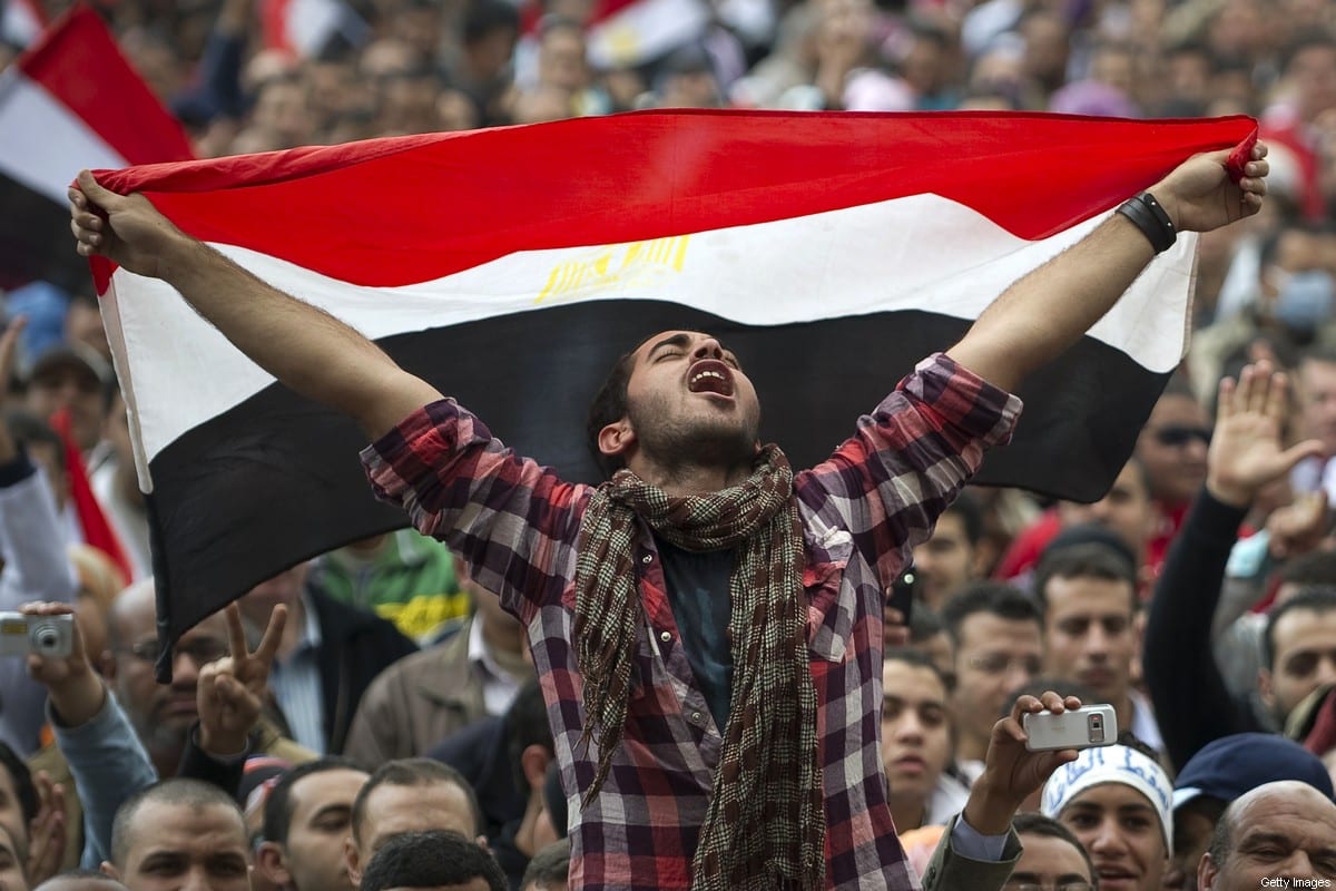 Um egípcio segura sua bandeira nacional enquanto grita palavras de ordem contra o presidente Hosni Mubarak na Praça Tahrir, no Cairo, em 10 de fevereiro de 2011 [Pedro Ugarte/AFP/Getty Images]
