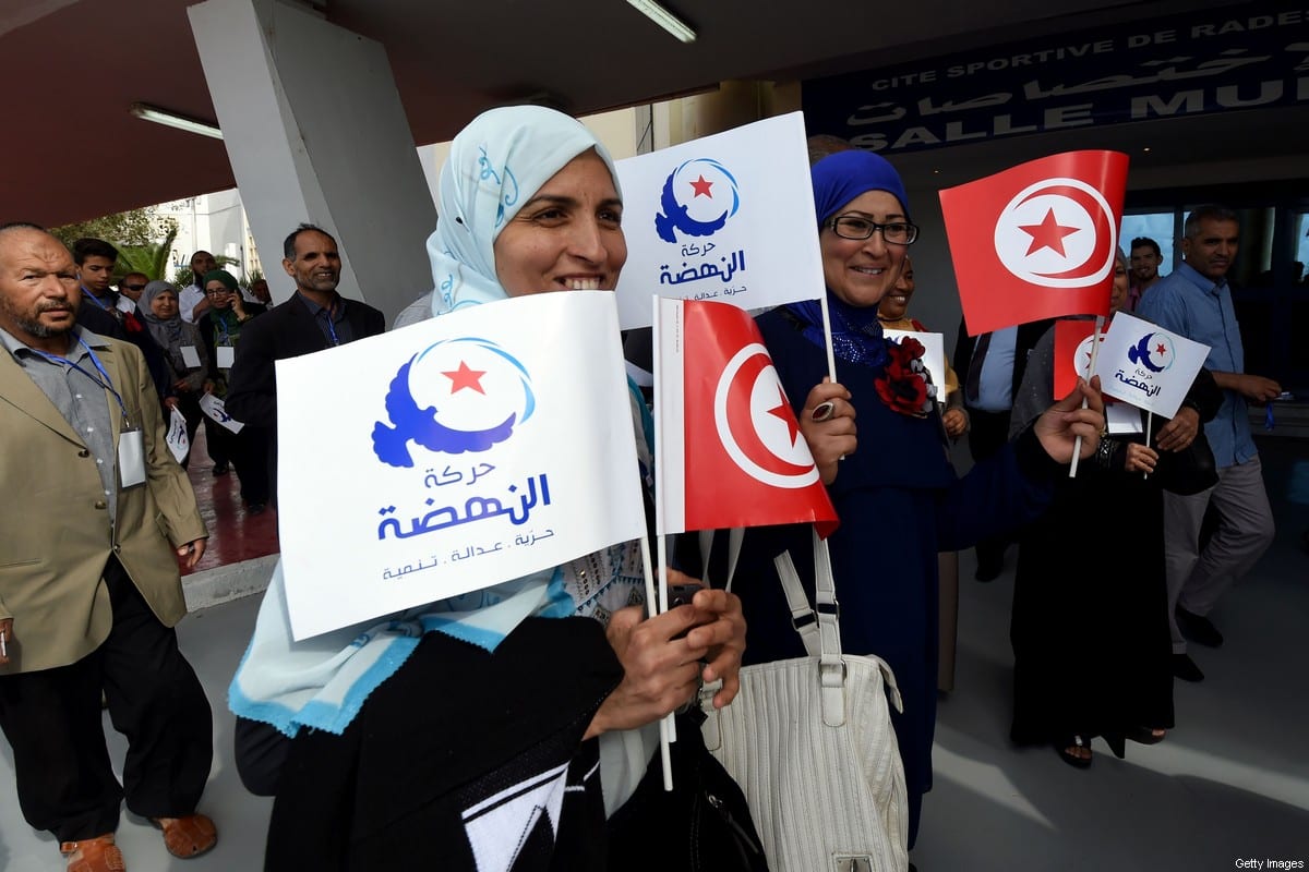 Apoiadores do partido islâmico Ennahdha da Tunísia agitam a bandeira nacional e a bandeira do partido, em 20 de maio de 2016 [Fethi Belaid/AFP via Getty Images]
