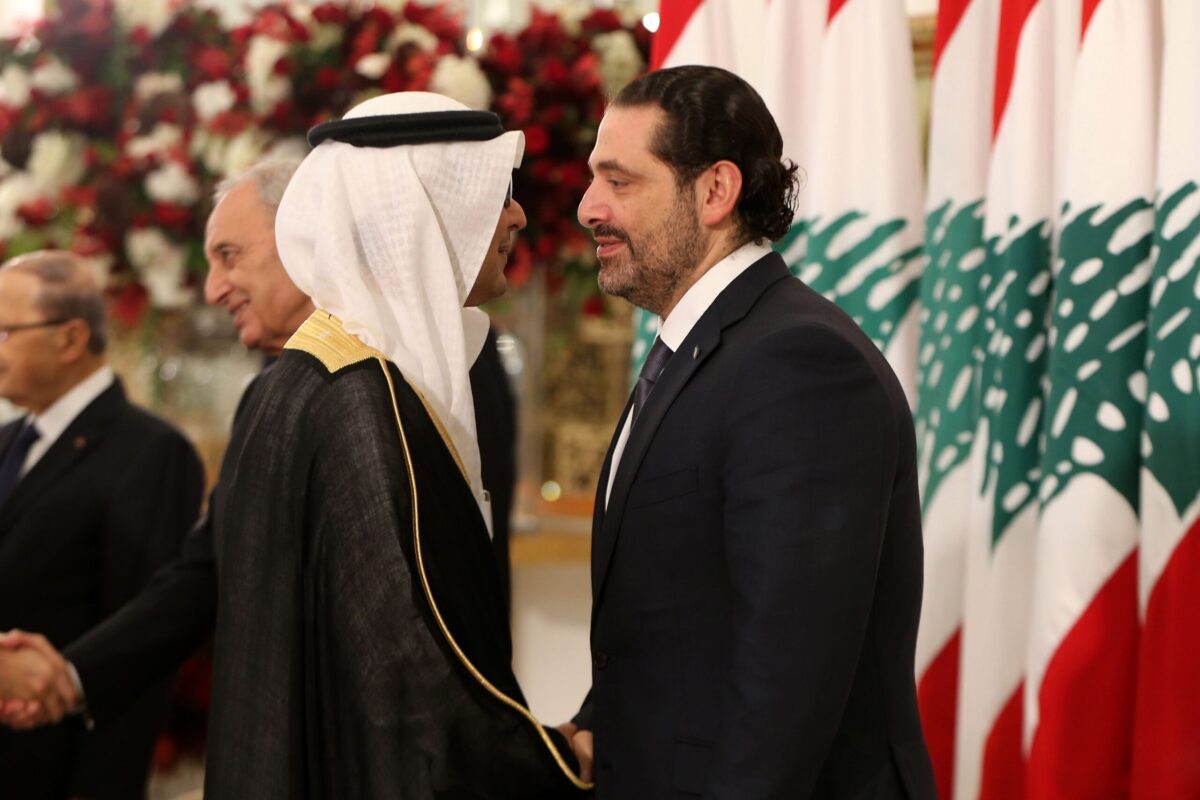 Encarregado de negócios saudita, Walid al-Bukhari, aperta a mão do ex-primeiro-ministro libanês Saad Hariri durante uma cerimônia no palácio presidencial em Baadba, em 22 de novembro de 2017 [AFP via Getty Images]