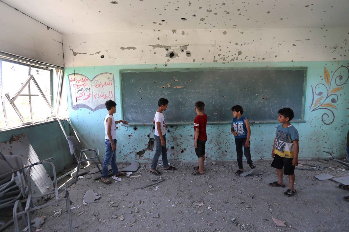 Crianças são vistas dentro de uma escola danificada após os ataques israelenses na cidade de Gaza, Gaza, em 26 de maio de 2021 [Ahraf Amra/Agência Anadolu]
