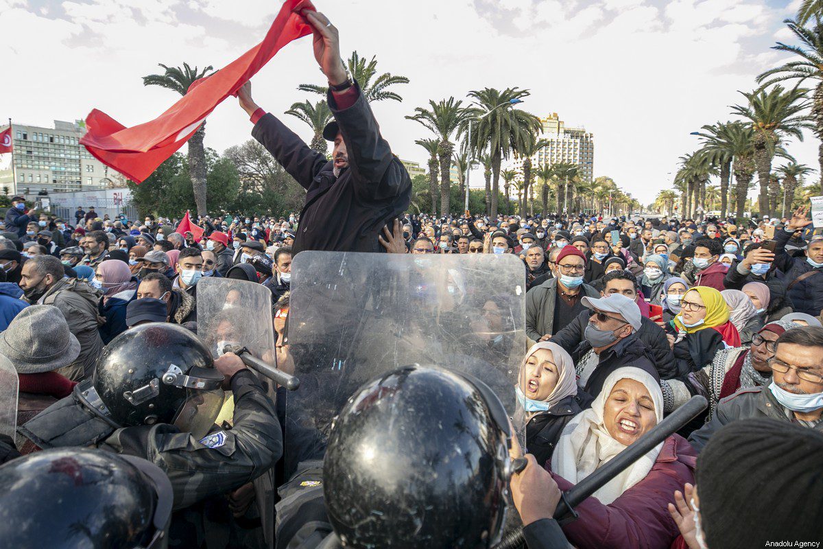 Tunisianos entram em confronto com forças de segurança durante manifestação contra o presidente Kais Saied, no 11º aniversário da revolução tunisiana na capital Túnis, em 14 de janeiro de 2022 [Yassine Gaidi/Agência Anadolu]
