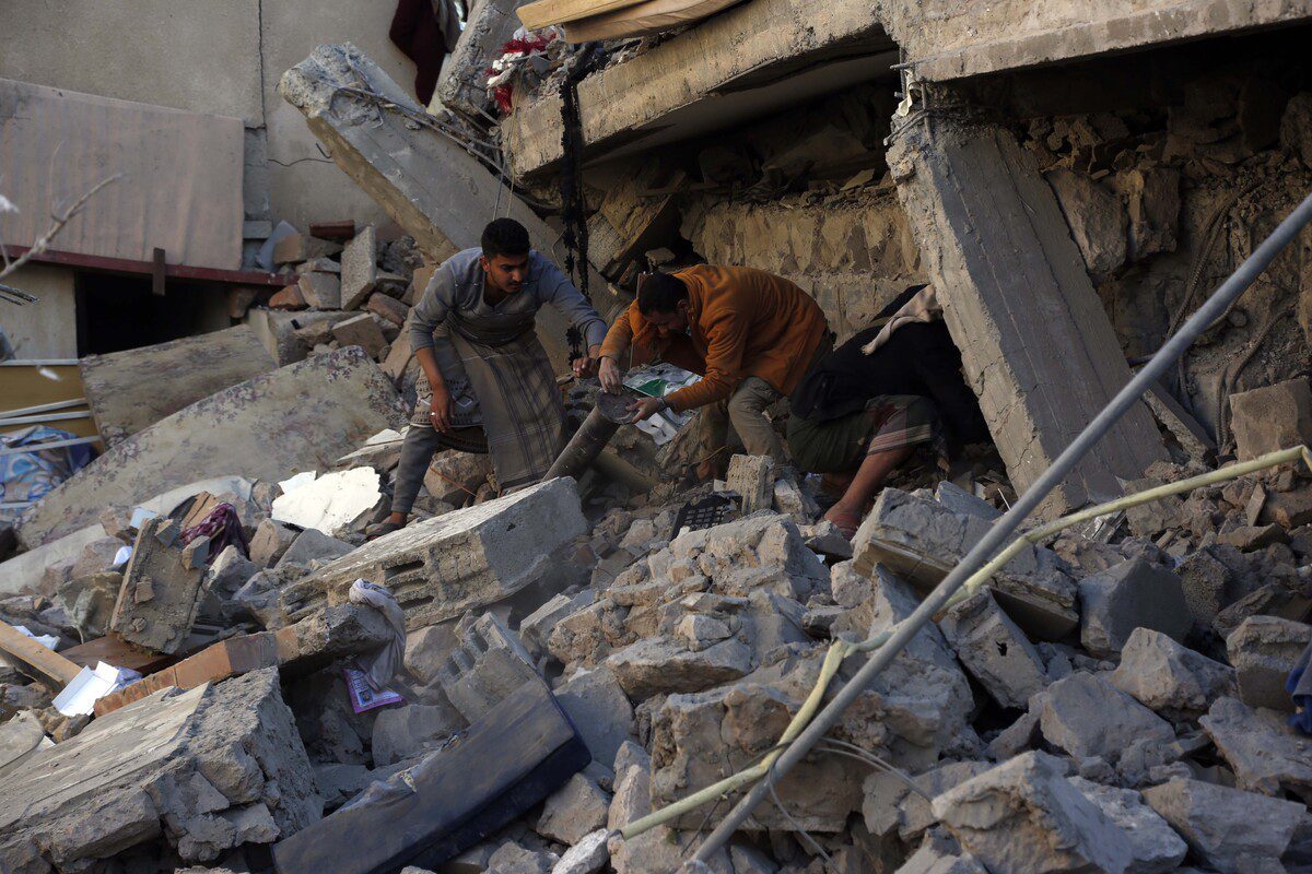 Os iemenitas inspecionam os danos depois que as forças da coalizão liderada pela Arábia Saudita anunciaram que estão realizando ataques aéreos em Sanaa em resposta aos últimos ataques a Abu Dhabi, capital dos Emirados Árabes, pelos houthis na capital Sanaa, Iêmen, em 18 de janeiro de 2022 [Mohammed Hamoud/Agência Anadolu]
