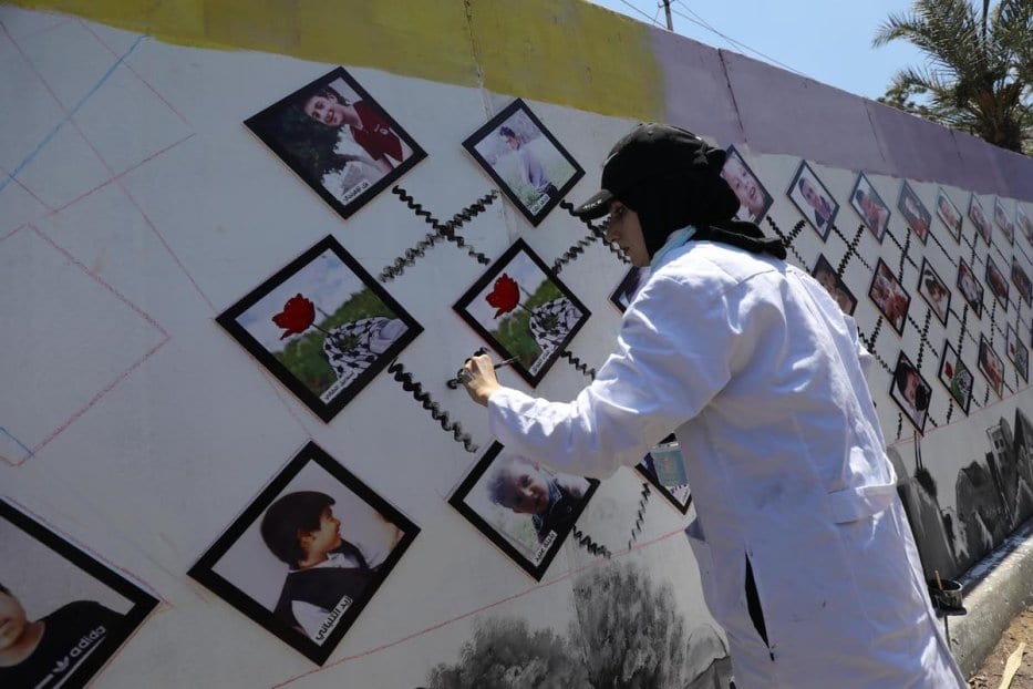 Artistas exibem imagens de crianças palestinas mortas pelos bombardeios israelenses em Gaza ocorridos em maio de 2021, em frente ao escritório local do Programa das Nações Unidas para o último (PNUD), em 13 de julho de 2021 [Mohammed Asad/Monitor do Oriente Médio]
