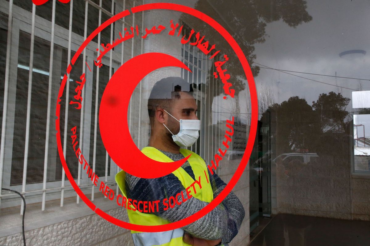 Um trabalhador da Sociedade do Crescente Vermelho, em Hebron, na Cisjordânia ocupada, em 15 de março de 2020 [Hazem Bader/AFP via Getty Images]
