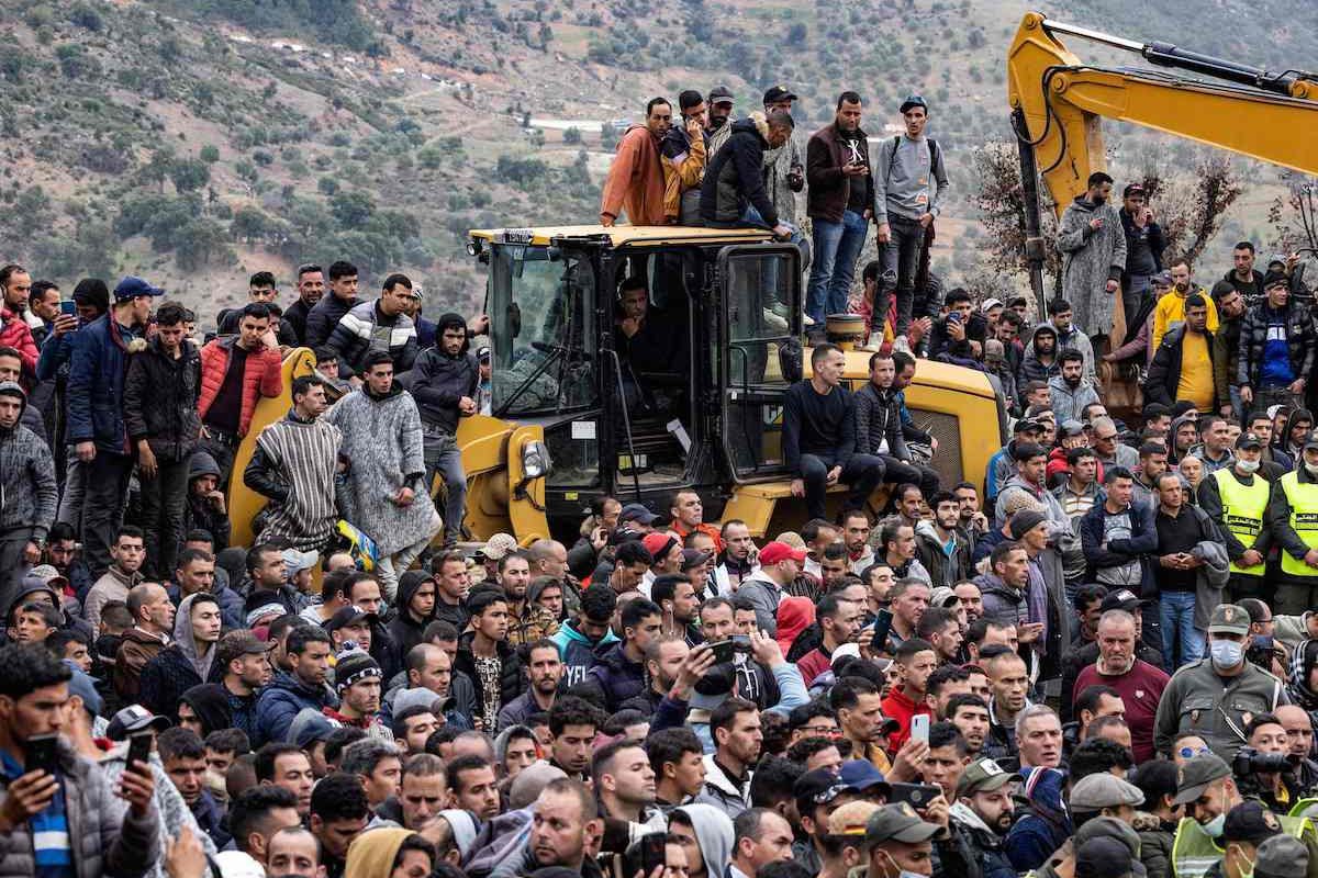 Multidão assiste operação de resgate de um menino de cinco anos que caiu em um poço na aldeia remota de Ighrane, na província rural de Chefchaouen, norte do Marrocos, em 5 de fevereiro de 2022 [FADEL SENNA/AFP via Getty Images]
