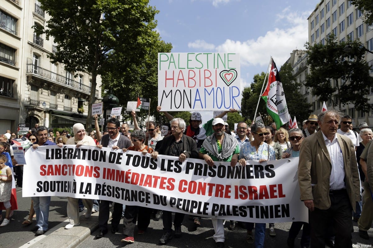 Manifestantes seguram um cartaz com os dizeres "Palestine Habibi my love" durante uma manifestação contra as operações militares de Israel em Gaza e em apoio ao povo palestino, em 2 de agosto de 2014, em Paris [Kenzo Tribouillard/AFP via Getty Images]
