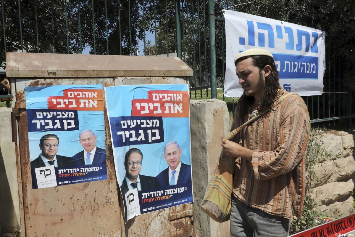 Colono passa ao lado de cartazes de campanha do então premiê israelense Benjamin Netanyahu, na cidade de Hebron (Al-Khalil), na Cisjordânia ocupada, 4 de setembro de 2019 [HAZEM BADER/AFP via Getty Images]
