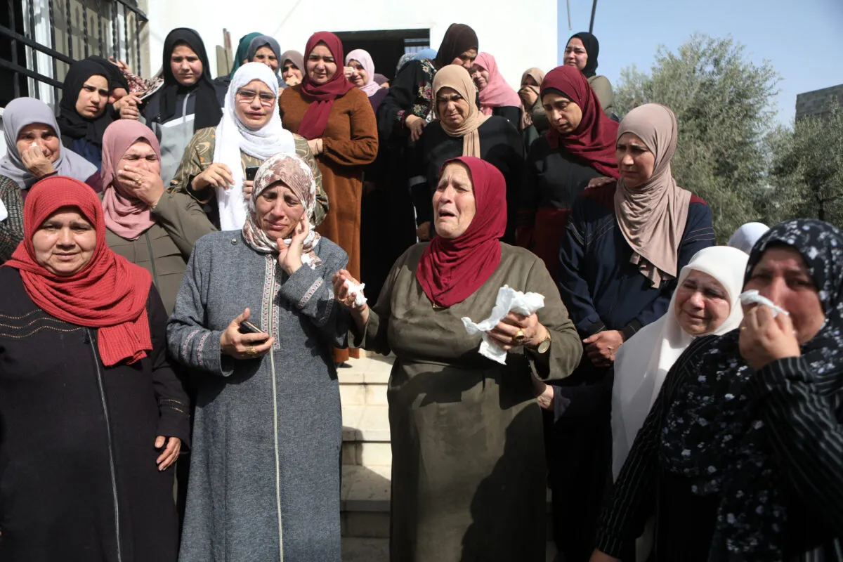 Parentes choram durante o funeral de Ghada Sabatin, 47, que morreu de seus ferimentos após ser baleada por soldados israelenses, na vila de Husan, a oeste da cidade de Belém, na Cisjordânia ocupada, em 10 de abril de 2022 [Wisam Hashlamoun/Agência Anadolu]

