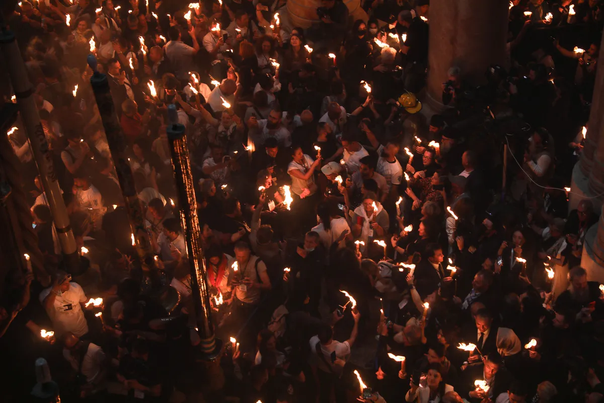 Cristãos ortodoxos durante a cerimônia do Fogo Sagrado, na Igreja do Santo Sepulcro, em Jerusalém ocupada, 23 de abril de 2022 [Mostafa Alkharouf/Agência Anadolu]
