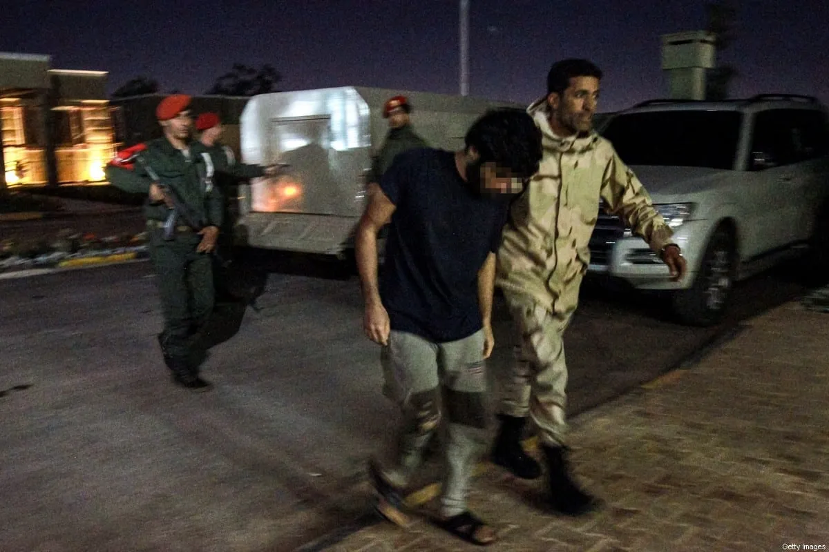 Um soldado pró-Haftar escoltando um prisioneiro capturado pelas forças de Haftar durante sua ofensiva nas proximidades da capital Trípoli, supostamente parte de mercenários da Síria [Abdullah Doma/AFP via Getty Images]
