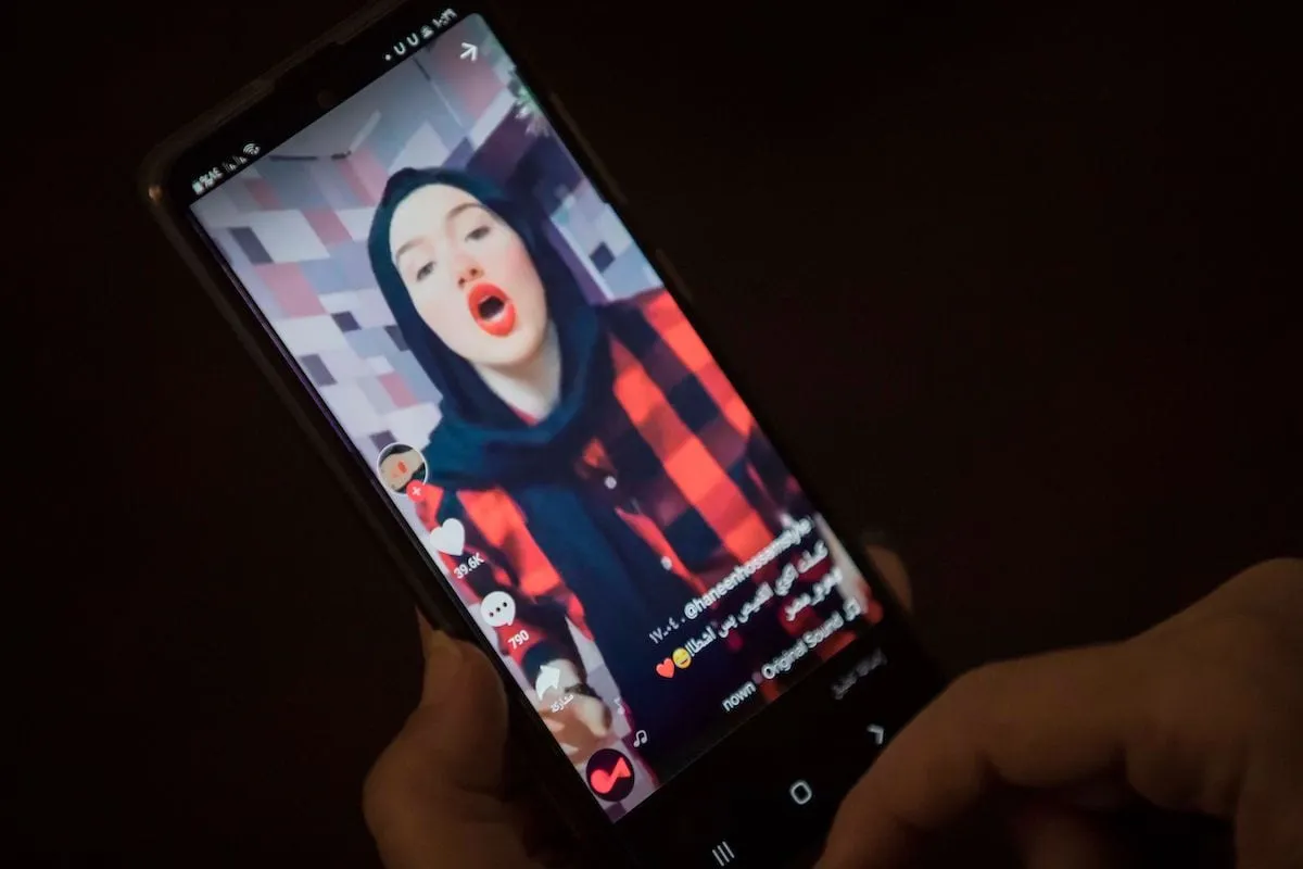Uma mulher assiste a um vídeo da influenciadora egípcia Haneen Hossam, condenada a dois anos de prisão por violação da moral pública, no aplicativo de compartilhamento de vídeos TikTok na capital do Egito, Cairo, em 28 de julho de 2020 [Khaled Desouki/AFP via Getty Images ]

