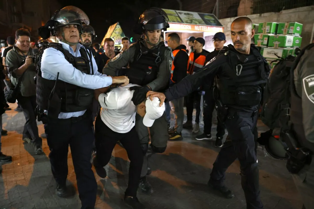 Forças de segurança israelenses detêm um jovem palestino do lado de fora do Portão de Damasco, na Cidade Velha de Jerusalém, em 5 de abril de 2022 [Ahmad Gharabli/AFP via Getty Images]