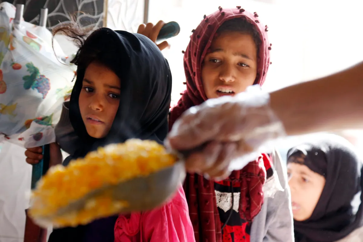 Meninas aguardam refeição em um sopão humanitário na área de Mseek, em Sana’a, capital do Iêmen, em 3 de abril de 2022 [Mohammed Hamoud/Getty Images]