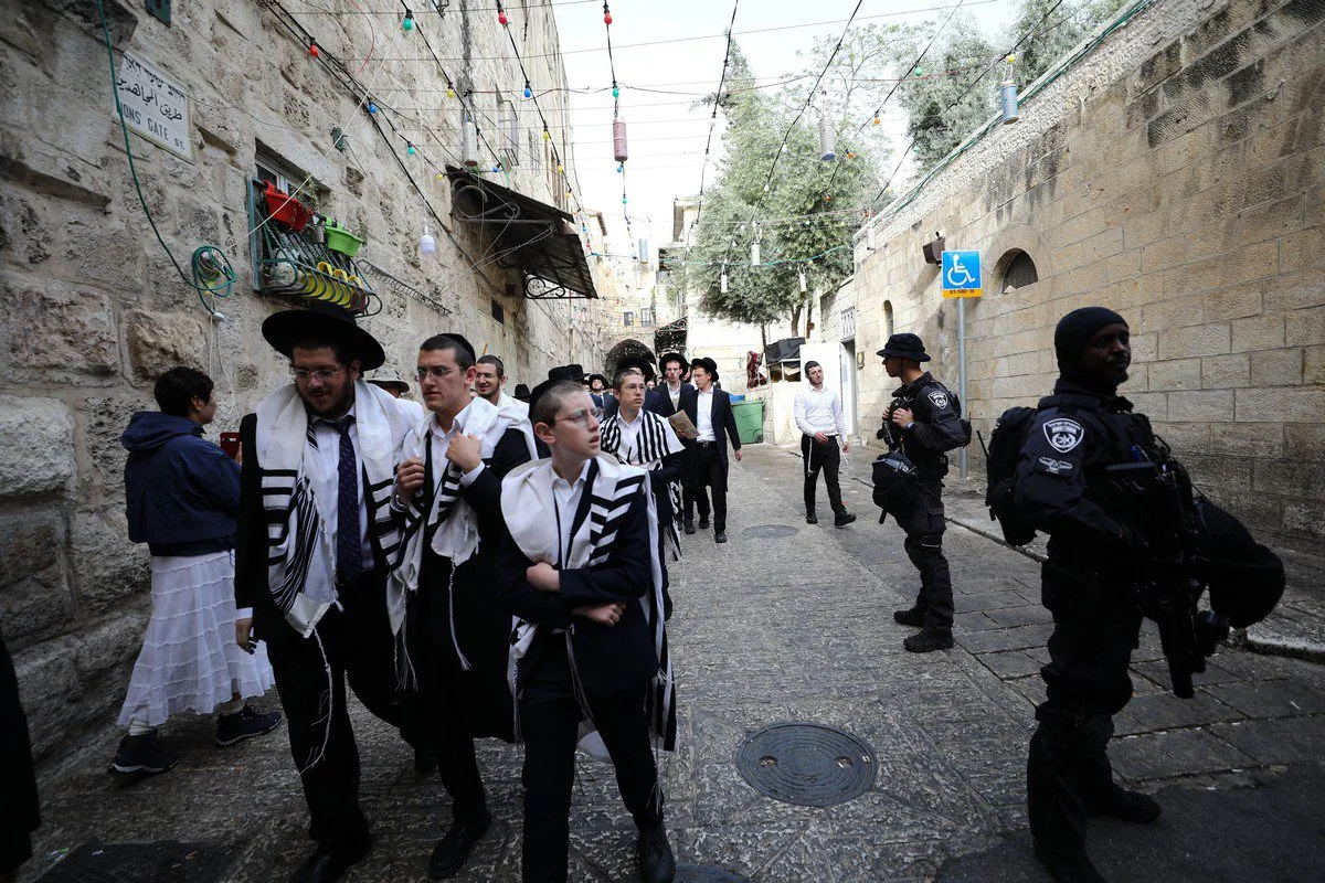 Colonos judeus escoltados por forças israelenses entram no complexo da Mesquita de Al-Aqsa depois que a polícia expulsa fiéis palestinos após uma oração matinal, em Jerusalém, em 18 de abril de 2022 [Mostafa Alkharouf/Agência Anadolu]
