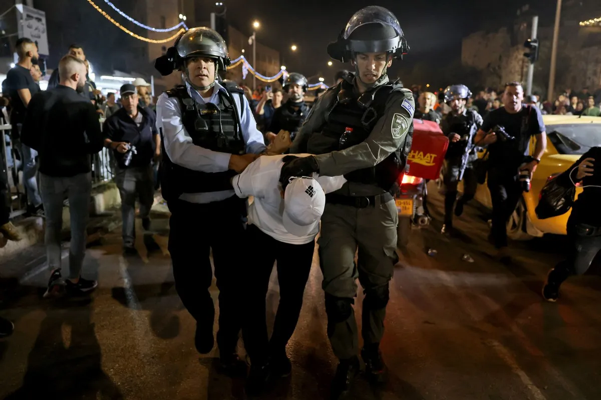 Forças de segurança israelenses detêm um adolescente palestino na Cidade Velha de Jerusalém durante o mês sagrado do Ramadã, em 5 de abril de 2022 [Ahmad Gharabli/AFP/Getty Images] 
