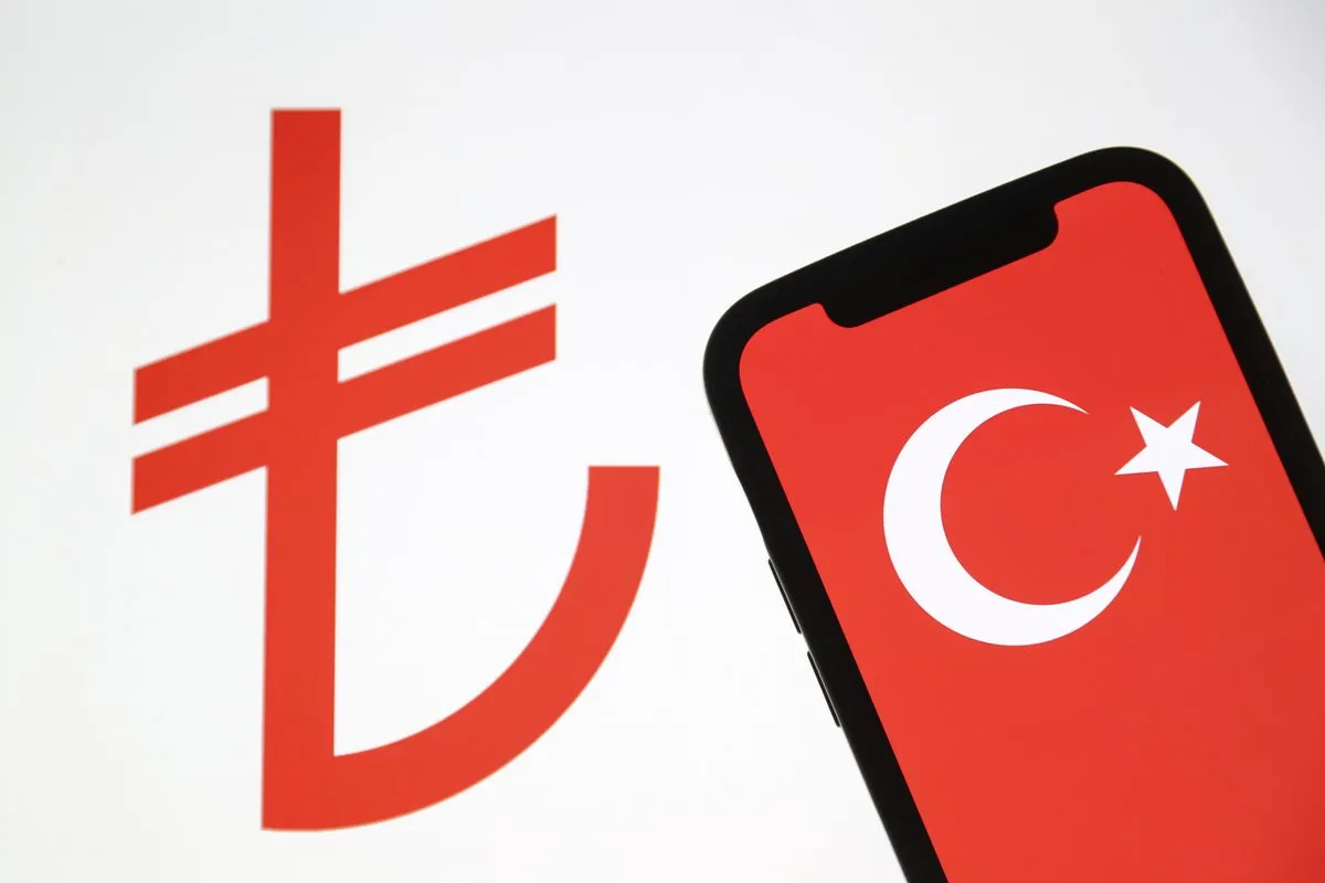 Bandeira da Turquia e símbolo da lira turca em aparelhos eletrônicos, em Ancara, 3 de maio de 2022 [Celal Günes/Agência Anadolu]