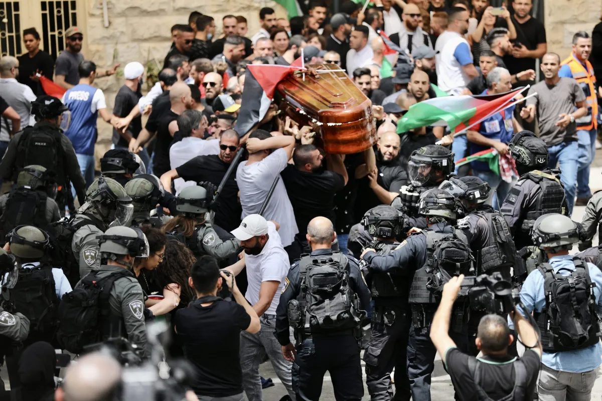 Forças israelenses atacam palestinos que carregavam o caixão da jornalista morta da Al-Jazeera Shireen Abu Akleh, em 13 de maio de 2022 [Mostafa Alkharouf/Agência Anadolu]
