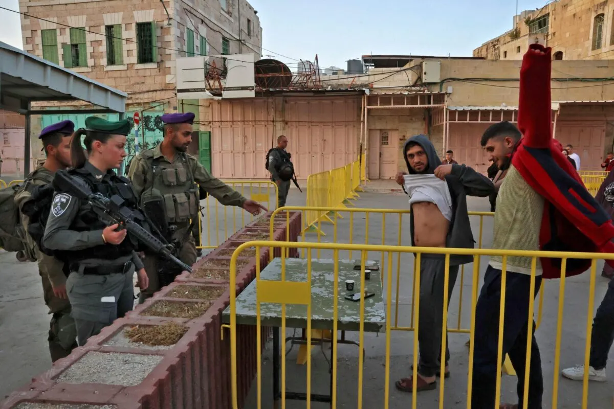 Polícia de fronteira israelense realiza verificações de segurança em palestinos na cidade velha de Hebron, na Cisjordânia, em 02 de maio de 2022 [Hazem Bader/AFP via Getty Images]
