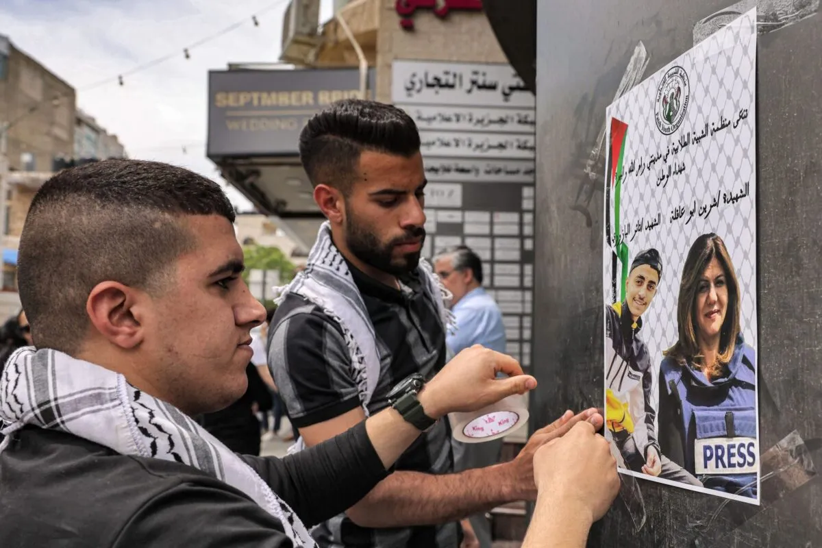 Pessoas se reúnem nos escritórios da Al Jazeera na cidade de Ramallah, na Cisjordânia, em 11 de maio de 2022, após o assassinato da jornalista veterana Shireen Abu Aqleh, que foi morta a tiros enquanto cobria uma operação no campo de refugiados de Jenin, na Cisjordânia [Ronaldo Schemidt/AFP via Getty Images]
