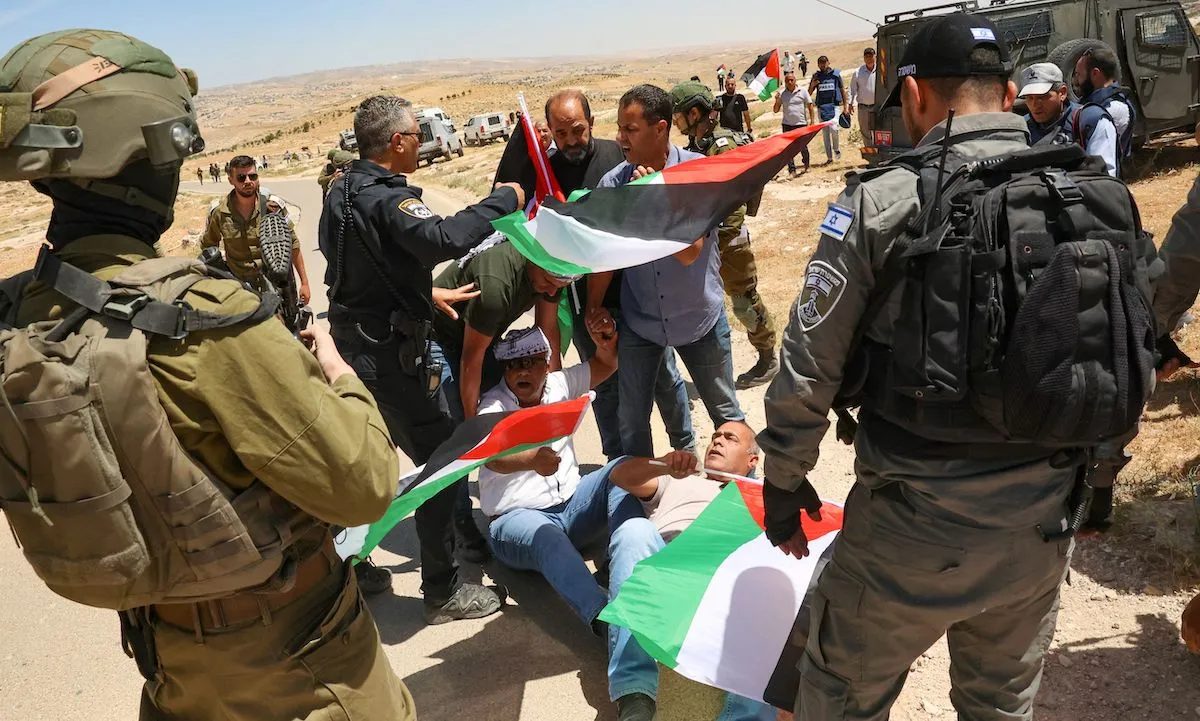 Soldados israelenses reprimem protesto contra a evacuação de aldeias palestinas para dar lugar a uma ‘zona de treinamento militar’, em Yatta, na região de Hebron (Al-Khalil), no sul da Cisjordânia ocupada, em 20 de maio de 2022 [Hazem Bader/AFP via Getty Images]
