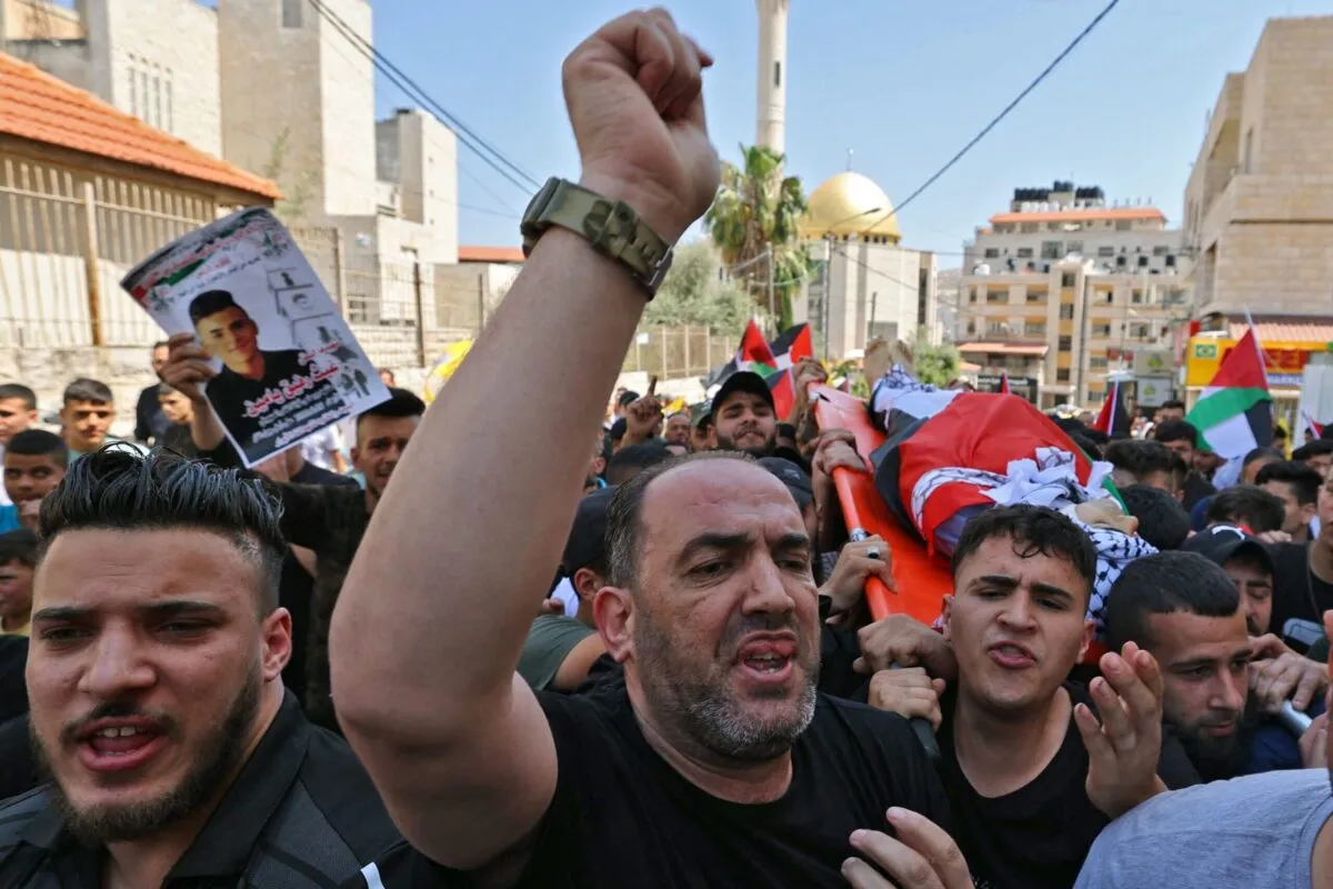 Enlutados palestinos carregam o corpo de Ghaith Yamin, morto durante confrontos com as forças de segurança israelenses na cidade ocupada de Nablus, na Cisjordânia, em 25 de maio de 2022 [Jaafar Ashtiyeh/AFP via Getty Images]
