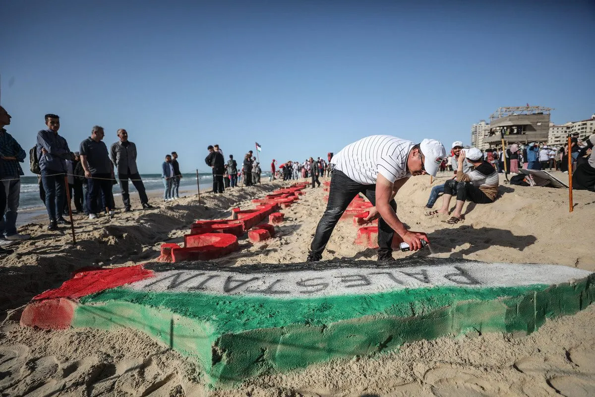 Artistas palestinos fazem um mapa-bandeira da Palestina com areias para lembrar o 74º aniversário da Nakba, na Cidade de Gaza, Gaza, em 8 de maio de 2022. [Mustafa Hassona/Agência Anadolu]
