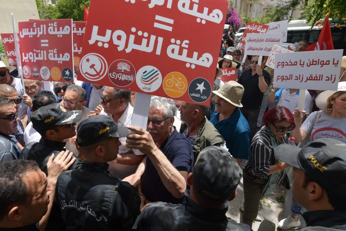 O porta-voz do partido trabalhista tunisiano Hamma Hammami (C) está entre os manifestantes bloqueados pela polícia enquanto se dirigiam para a sede da autoridade eleitoral ISIE, durante uma manifestação contra seu presidente, na capital Tunis, em 4 de junho de 2022 [ Fethi Belaid/ELAID/AFP via Getty Images]
