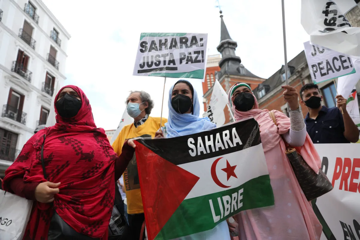 Mulheres saharauis de máscaras exibem bandeiras saharauis durante a manifestação de 18 de junho de 2021 em Madrid, Espanha [Isabel Infantes/Getty Imagens]
