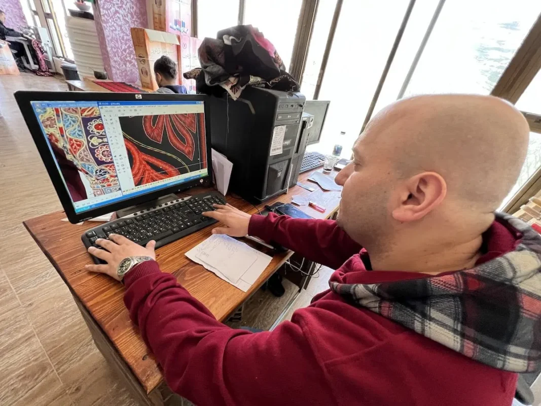 Máquinas de bordado por computador produzem os tradicionais robes palestinos na Faixa de Gaza sitiada, em 19 de julho de 2022 [Mohammed Asad/Monitor do Oriente Médio]