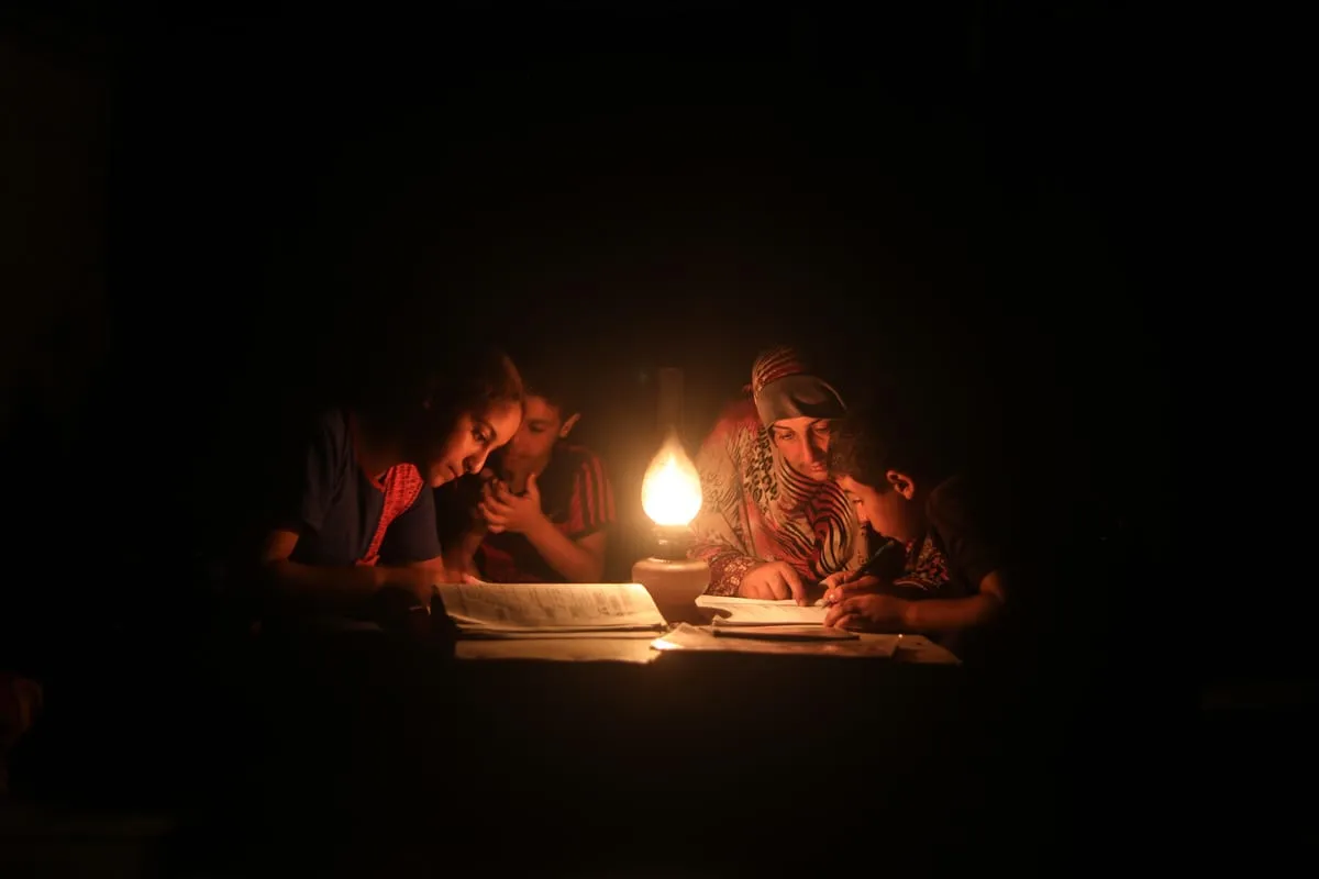 Crianças estudam a luz de velas durante blecaute em Khan Yunis, na Faixa de Gaza, 18 de agosto de 2018 [Mustafa Hassona/Agência Anadolu]
