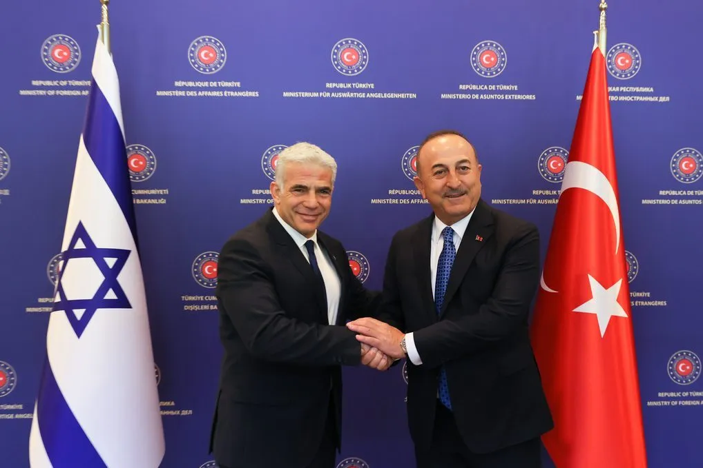O ministro das Relações Exteriores da Turquia Mevlut Cavusoglu (dir.) aperta a mão do ministro das Relações Exteriores israelense Yair Lapid (esq.) enquanto posam para uma foto antes de sua reunião em Ancara, Turquia em 23 de junho de 2022 [Cem Özdel - Agência Anadolu]

