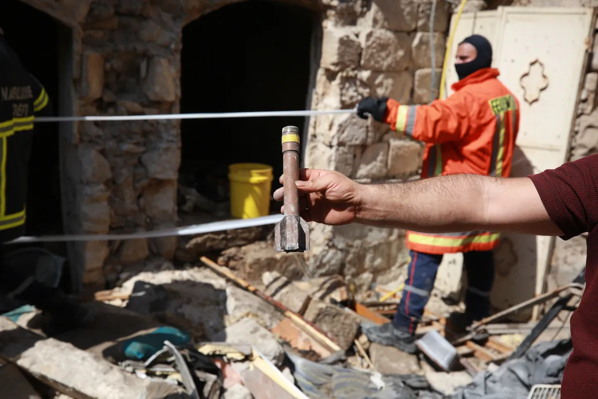 Bombeiros inspecionam local de um ataque israelense em Nablus, na Cisjordânia ocupada, 9 de agosto de 2022 [Issam Rimawi/Agência Anadolu]