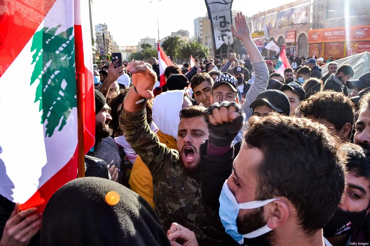 Manifestantes antigovernamentais cantam slogans durante uma manifestação em Trípoli, Líbano, em 31 de janeiro de 2021 [Fathi Al-Masri /AFP/Getty Images]
