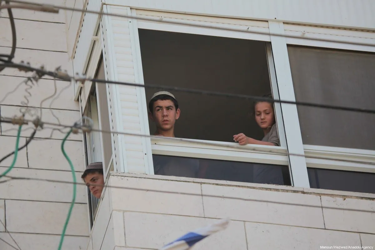 Colonos instalados em uma casa palestina após expulsarem seus residentes da propriedade, em Hebron (Al-Khalil), na Cisjordânia ocupada, em 26 de julho de 2017 [Mamoun Wazwaz/Agência Anadolu]
