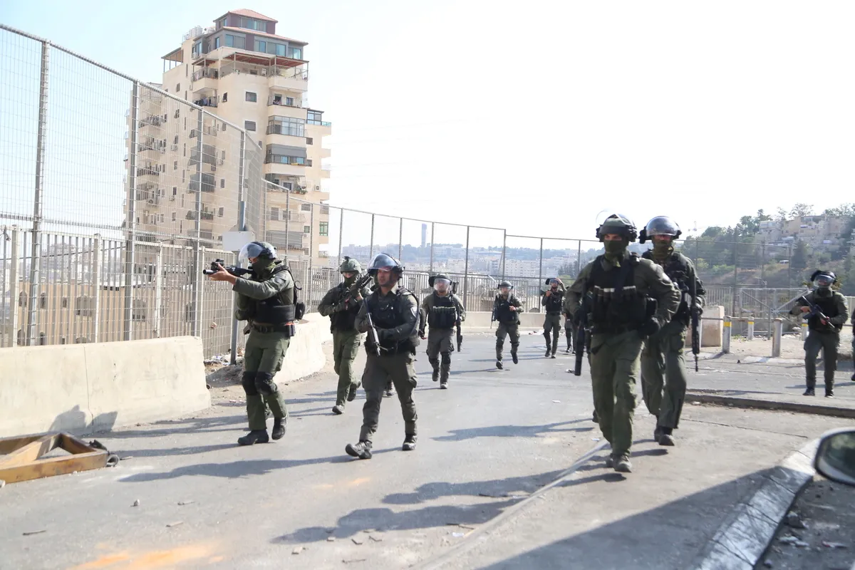 Soldados israelenses montam guarda durante um ataque do exército ao Campo de Refugiados de Shuafat que está sitiada desde 8 de outubro em Jerusalém Oriental em 11 de outubro de 2022 [Mücahit Aydemir/Agência Anadolu]
