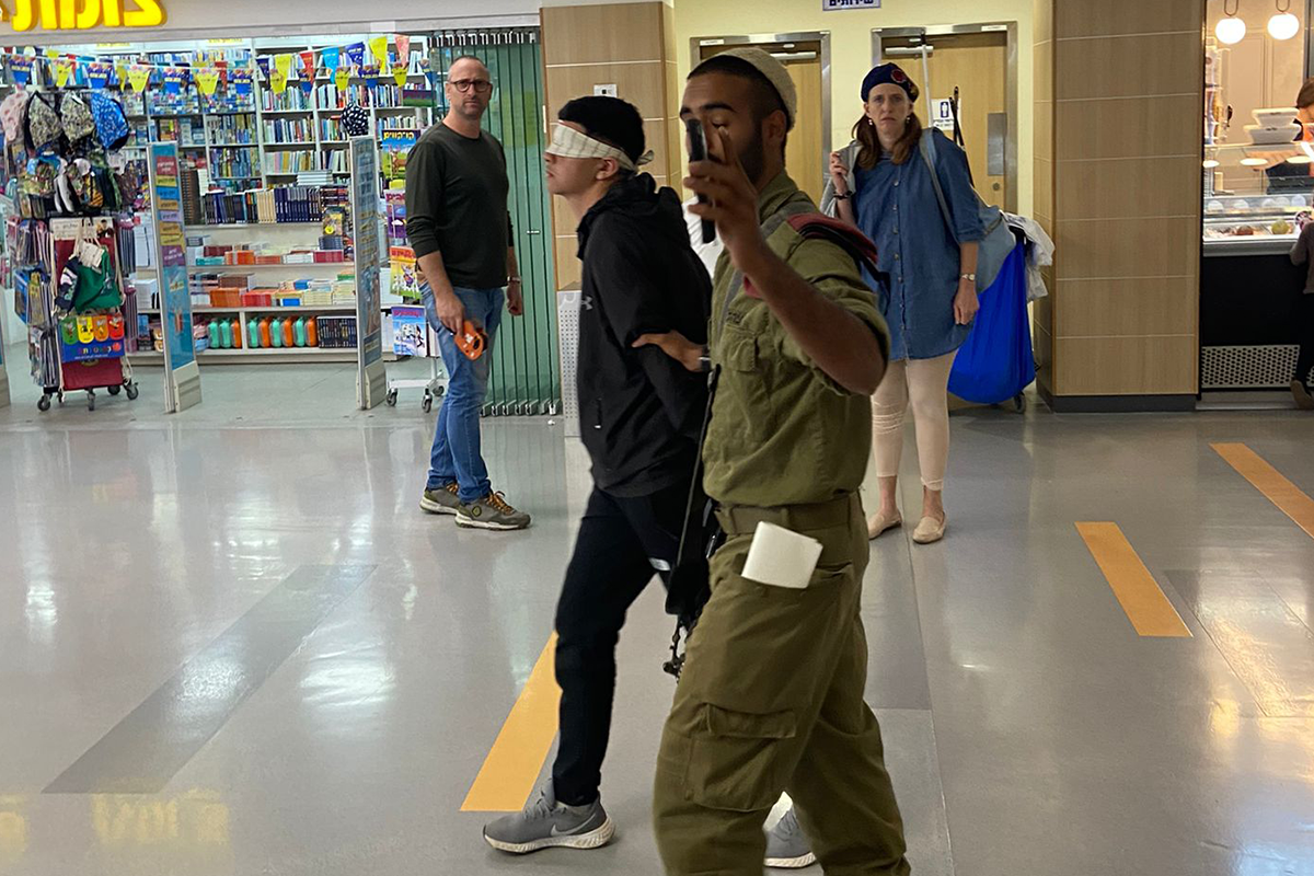 Soldado das Forças de Defesa de Israel (IDF) arrasta uma criança palestina com os olhos vendados através de um hospital para sua consulta médica Twitter]
