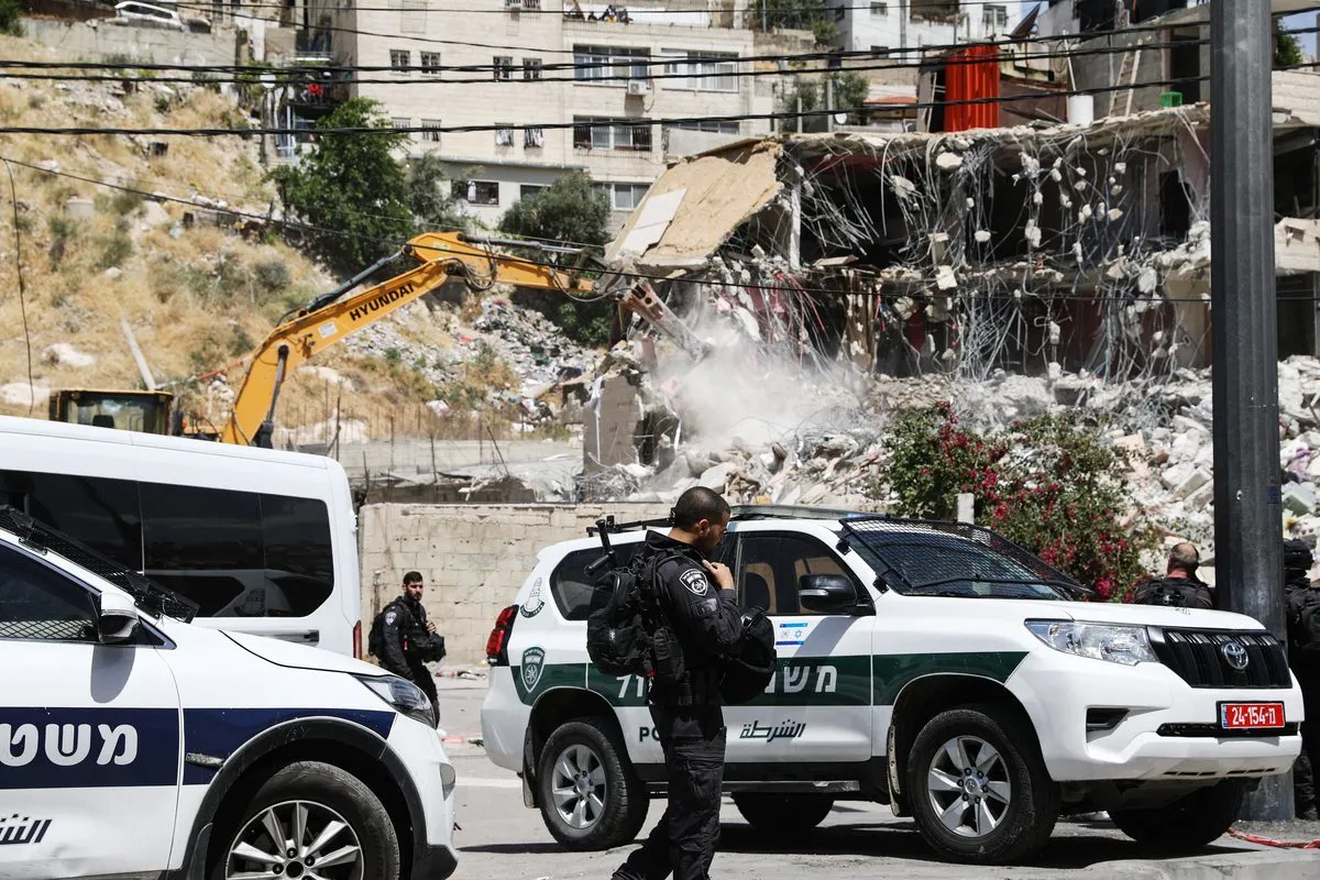Forças israelenses tomam medidas de segurança enquanto escavadeiras israelenses derrubam prédio de 2 andares no bairro de Silwan, em Jerusalém Oriental, Jerusalém em 10 de maio de 2022 [Mostafa Alkharouf/Agência Anadolu] 
