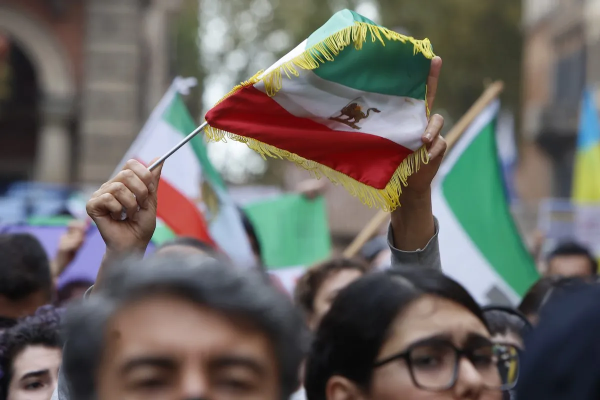 Manifestantes erguem cartazes e bandeiras iranianas em Roma, 19 de novembro de 2022 [Riccardo De Luca/Agência Anadolu]