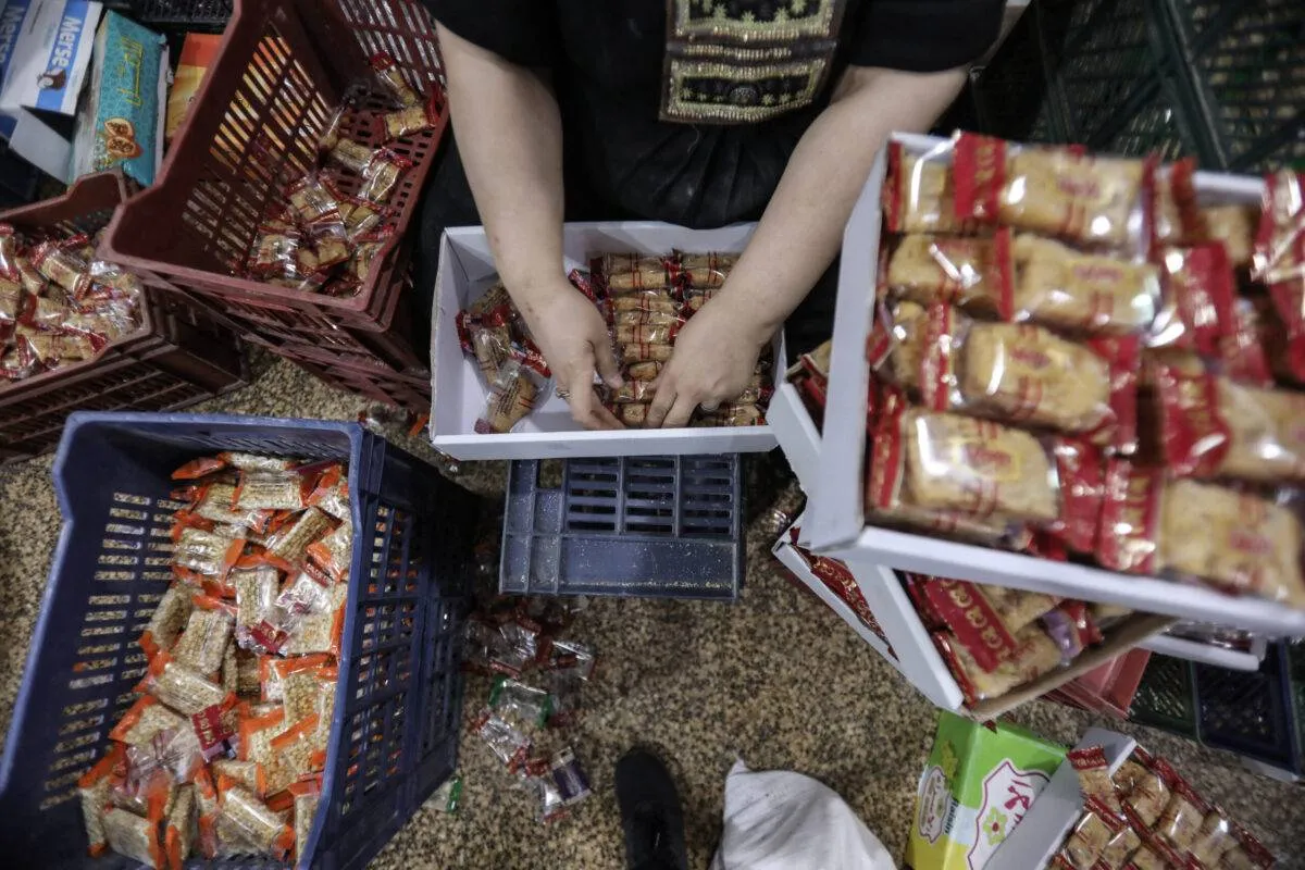 Trabalhadores embalam doces no Cairo, Egito, 4 de outubro de 2022 [Mohamed Abdel Hamid/Agência Anadolu via Getty Images]