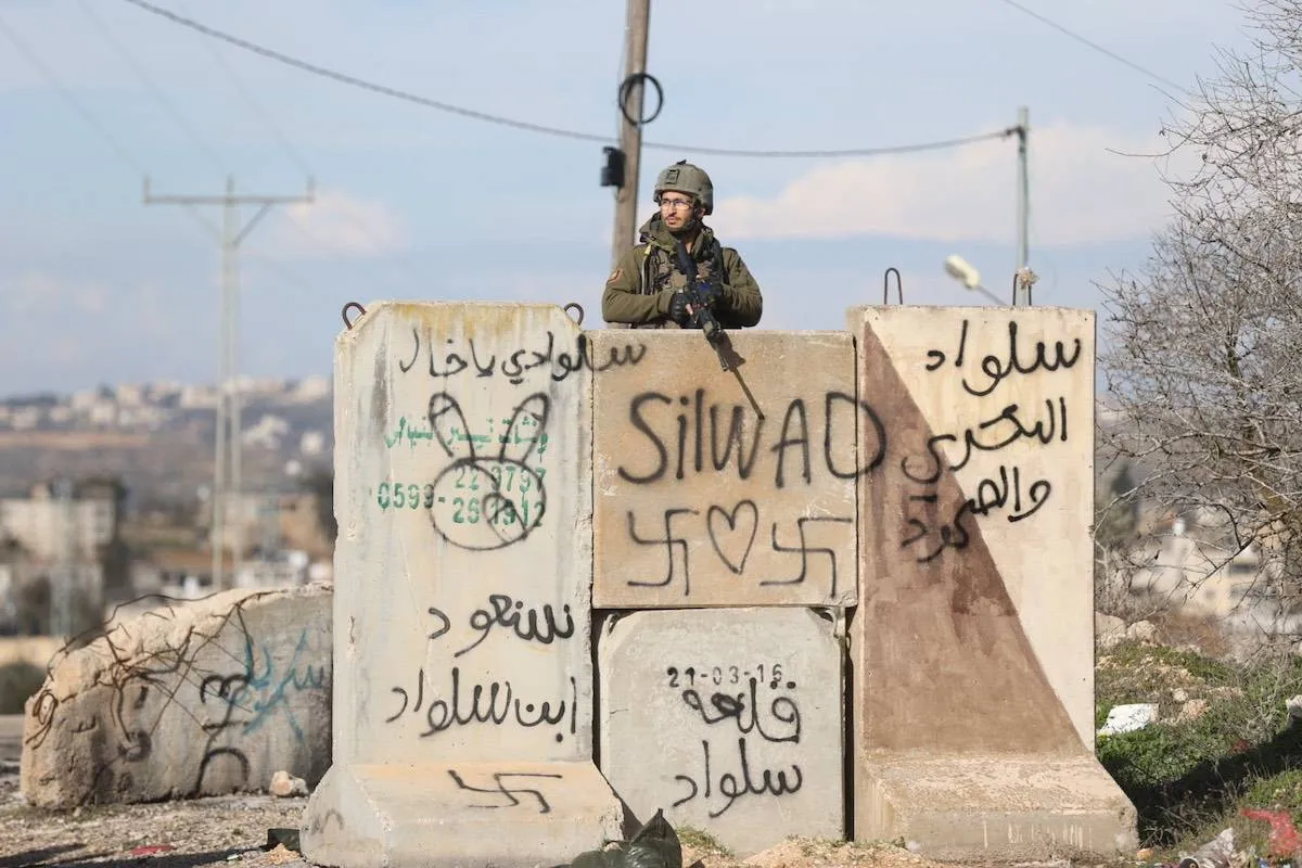 Soldados israelenses montam guarda após a morte a tiros de um residente palestino, no acesso oeste de Silwad, a norte de Ramallah, na Cisjordânia ocupada, em 15 de janeiro de 2023 [Issam Rimawi/Agência Anadolu]
