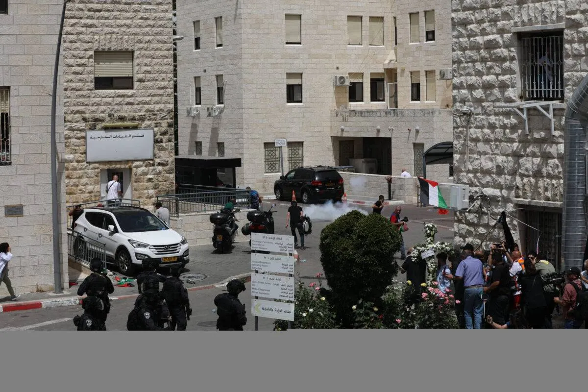 Soldados israelenses atacam pessoas em frente ao necrotério do Hospital São José de Jerusalém ocupada, em 13 de maio de 2022 [Mostafa Alkharouf/Agência Anadolu via Getty Images]
