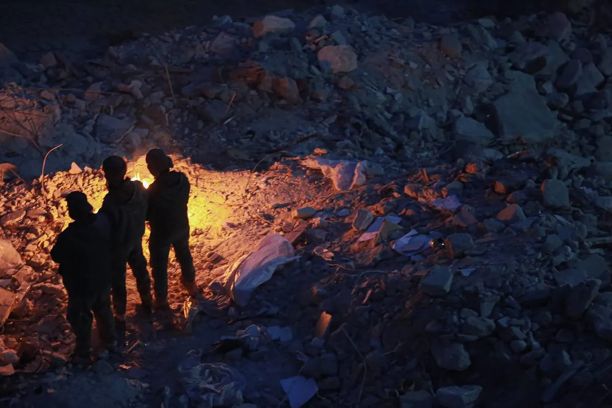 Grupo de resgate faz oração enquanto os esforços de busca de sobreviventes continuam após terremotos de magnitude 7,7 e 7,6 centrados em Kahramanmaras de Turquia, no distrito de Salqin em Idlib, Síria, em 09 de fevereiro de 2023 [Muhammed Said/Agência Anadolu]
