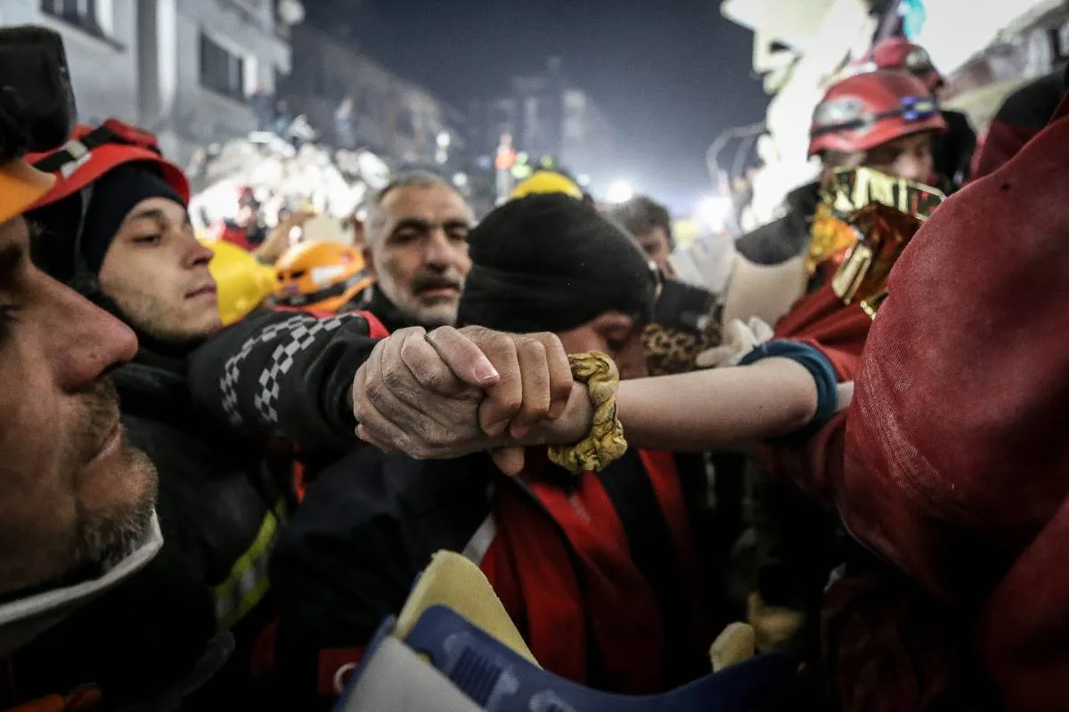 Equipe de resgate ajudando pessoas sob os escombros de um prédio desabado edifício, 209 horas após terremotos de magnitude 7,7 e 7,6 atingirem o distrito de Antakya em Hatay, Turquia, em 14 de fevereiro de 2023 [Sergen Sezgin/Ahmet Fatih İbrahimbaş]
