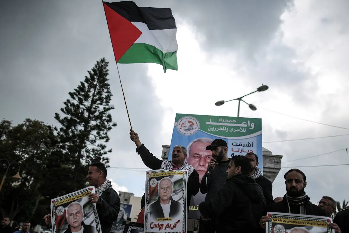 Manifestantes levantam a bandeira palestina durante protesto
