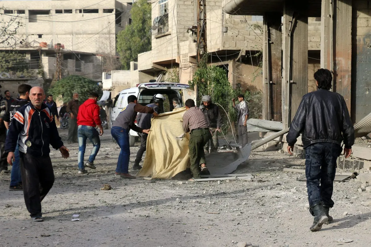 Membros da Defesa Civil e moradores tentam evacuar as vítimas após bombardeio executado pelo regime de Bashar al-Assad sobre a cidade de Seqba, controlada pela oposição, no distrito de Douma em Damasco, em 10 de novembro de 2016 [Samir Tatin/Agência Anadolu]